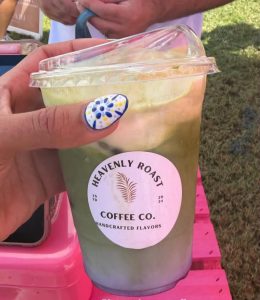 Iced matcha latte held by a happy customer at a market event