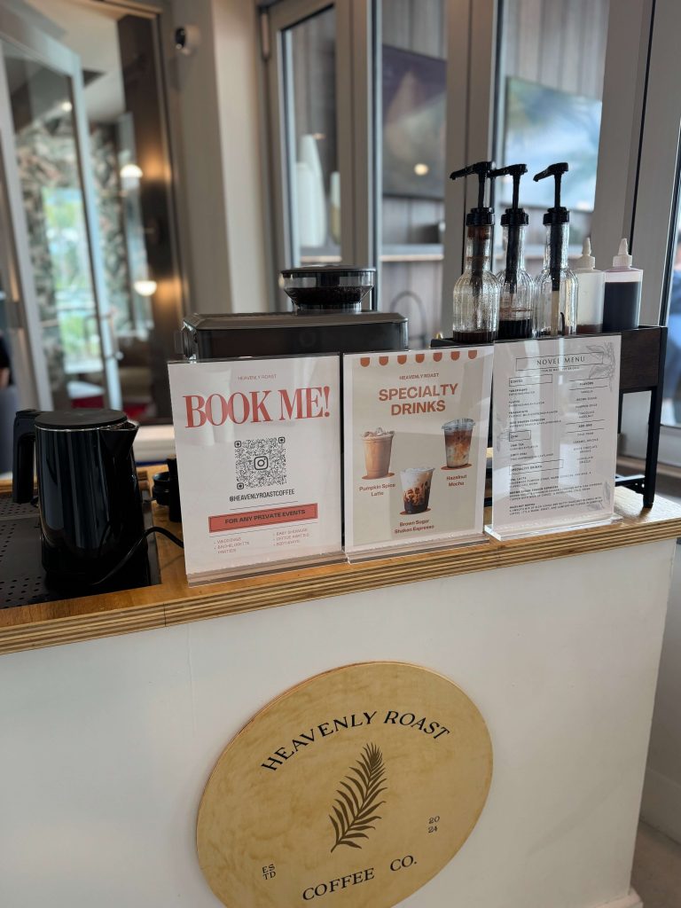 Heavenly Roast coffee cart counter with Book Me sign and specialty drinks menu
