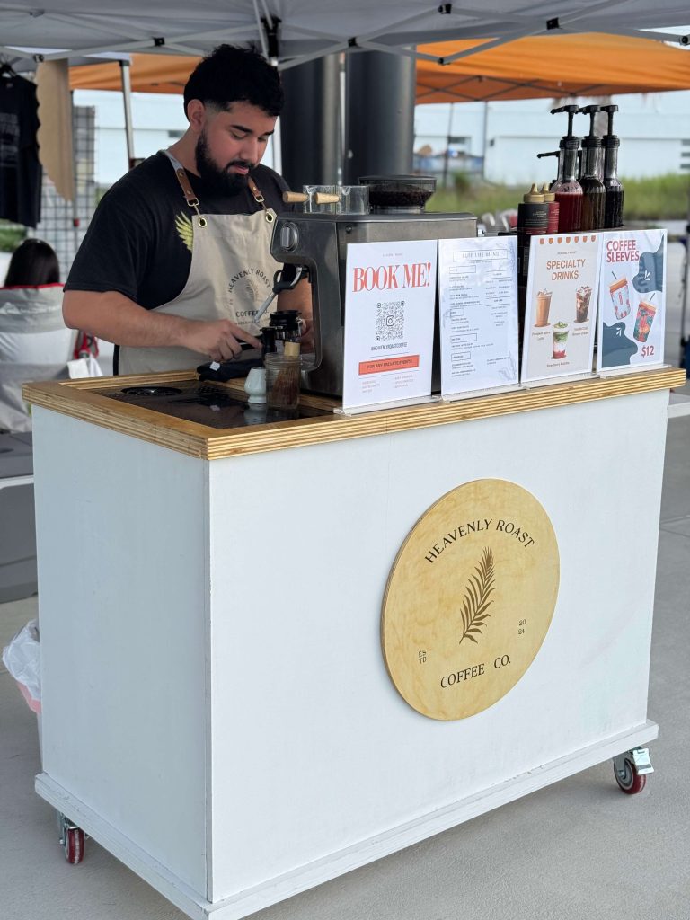 Heavenly Roast barista at the coffee cart with branded signage